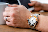 Aquacy Seiko Movement Watch Orange And Black On Wrist Holding Cup