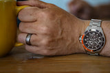 Aquacy Automatic Skeleton Watch Black And Orange On Wrist Holding Cup